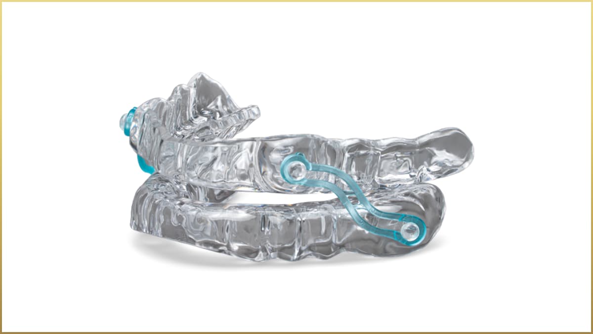 Clear plastic dental appliance with metal connectors designed to fit over the upper and lower teeth, used for oral or sleep therapy.